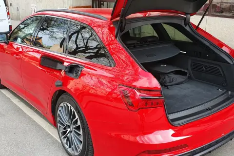 Röd Audi A6 Avant med öppet bagageutrymme. En svart väska ligger i det rymliga audi a6 bagageutrymmet.