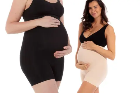 Dos mujeres embarazadas muestran ropa premamá. Descubre cuándo usar ropa premamá para mayor comodidad y soporte.