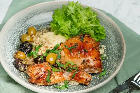 En härlig tallrik med kyckling, couscous, oliver och sallad. Ett perfekt medelhavskost recept kyckling för en smakrik måltid.