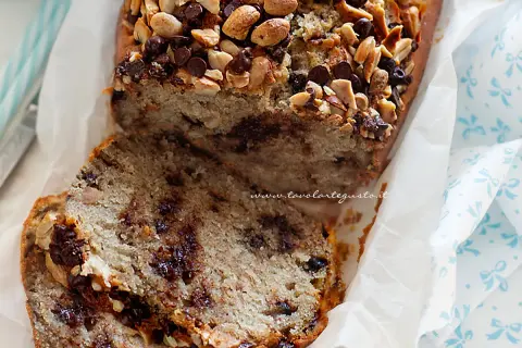 Plumcake alla banana soffice e goloso, con gocce di cioccolato e noci croccanti in superficie. Perfetto per la colazione o la merenda.