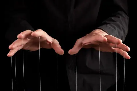 Dłonie trzymające nitki marionetki. Czas na zemstę na manipulancie, który myślał, że ma kontrolę.