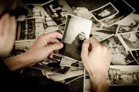 Ręce przeglądają stare fotografie, wspominając przeszłość. To piękny sposób na przechowywanie zdjęć i wspomnień.