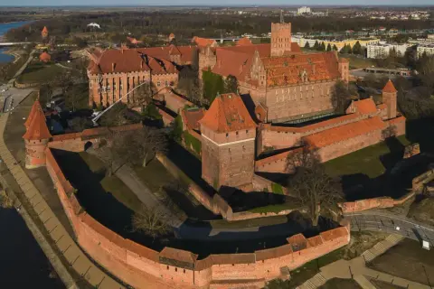 Potężny zamek w Malborku, z czerwonej cegły, otoczony murami obronnymi i fosą. Wspaniałe widoki, które potwierdzają pozytywne opinie o tym miejscu.