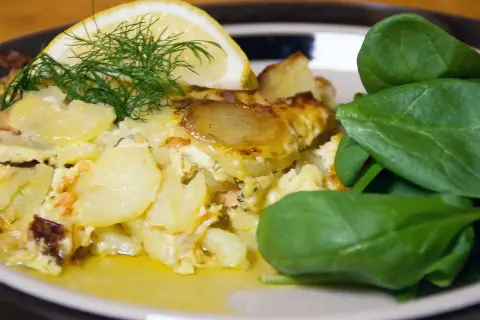 Enkel laxpudding med potatis, dill och citron. Serveras med färsk spenat.
