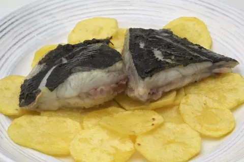 Rodaballo a la plancha servido sobre patatas fritas crujientes. Un plato sencillo y delicioso.
