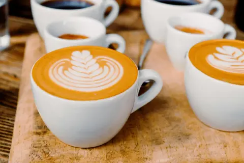 Tasses de café au lait avec une belle latte composition, sur fond de bois.