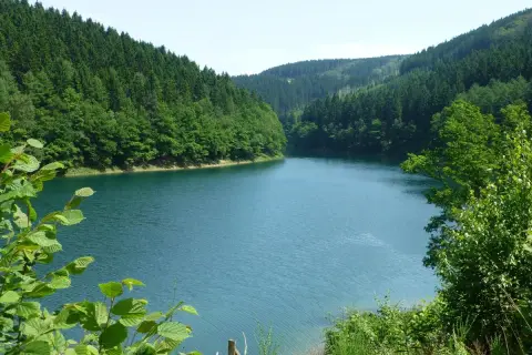 Idyllische Aggertalsperre mit bewaldeten Hängen. Perfekt für eine entspannte Wanderung am Wasser.