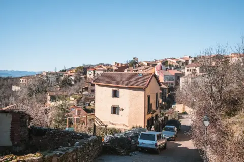 Casas de piedra y tejados rojos en un pueblo de montaña, hogar de los **habitantes Montejo de la Sierra**.