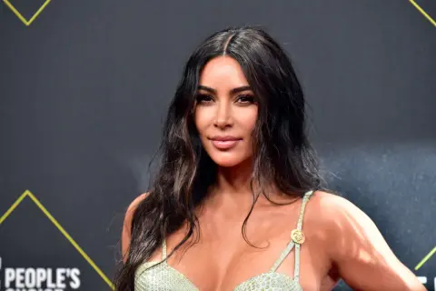Kim Kardashian w zielonej sukience z wężowym wzorem. Wiele osób zastanawia się, ile lat ma Kim Kardashian.