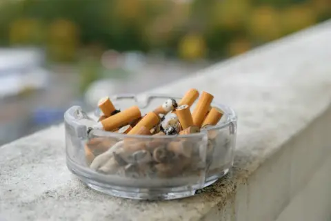 Popielniczka pełna niedopałków. Zastanawiasz się, ile wynosi akcyza na papierosy?