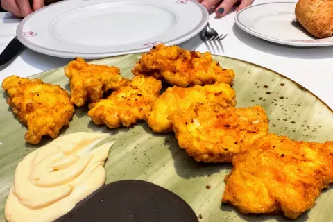 Crujientes fritos de pixin dorados, servidos con una cremosa salsa y un toque de oscuridad. ¡Un manjar para disfrutar!