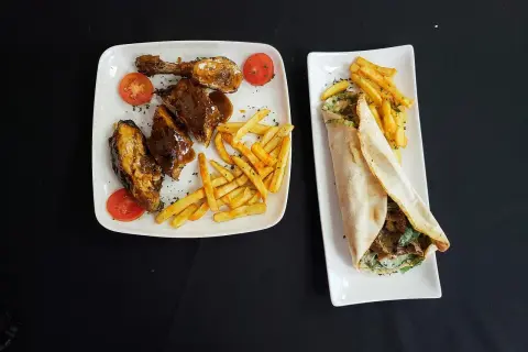 Dwa talerze z jedzeniem: żeberka w sosie z frytkami i pomidorkami, oraz wrap z mięsem i frytkami. Pytanie: halal co to?
