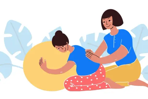 Una doula apoya a una mujer embarazada en una pelota de parto, ofreciendo consuelo y ayuda.