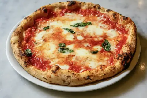 Eine authentische Pizza Margherita, wie sie in der Pizzeria Brandi in Neapel serviert wird, mit frischem Basilikum und geschmolzenem Mozzarella.