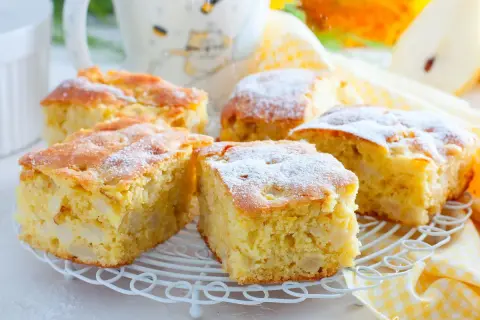 Pyszny przepis na ciasto z jabłkami, posypane cukrem pudrem. Idealne na jesienne popołudnie.