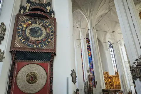 Wnętrze Bazyliki Mariackiej w Gdańsku. Imponujący zegar astronomiczny i witraże zachwycają podczas zwiedzania.
