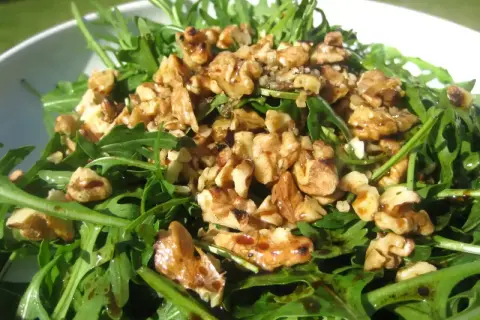 Ensalada de rucula fresca con nueces tostadas y un glaseado balsámico. Un plato ligero y sabroso.