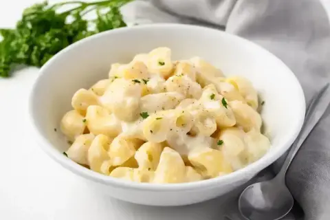 Pyszny makaron w kremowym sosie śmietanowym, posypany natką pietruszki. Idealny sos śmietanowy do makaronu na szybki obiad.