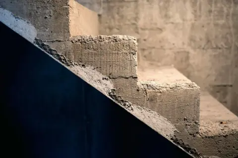 Surowe, betonowe schody czekają na wykończenie. Pomysły, jak tanio wykończyć schody betonowe, mogą obejmować malowanie lub położenie wykładziny.