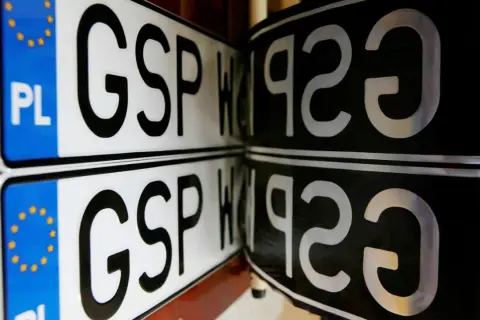 Dwie tablice rejestracyjne z napisem GSP. Jedna z nich ma niebieski pasek z gwiazdkami UE i literami PL.