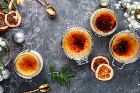 Tre krämiga crème brûlée i glasburkar, med karamelliserad yta. Perfekt för en mysig stund, detta är crème brûlée godaste!
