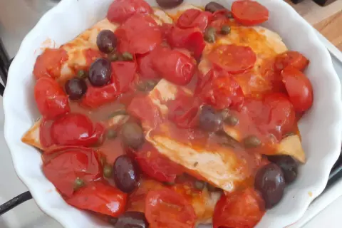 Petto di pollo alla pizzaiola in teglia, con pomodorini, olive nere e capperi. Un piatto saporito e colorato.