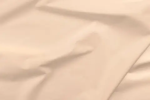 Gładka, beżowa popelina, która jest dobrym materiałem na letnie sukienki i koszule.
