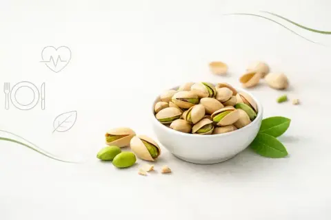 Miseczka pełna pistacji, które kuszą zielonym wnętrzem. Odkryj ich zdrowotne pistacje właściwości i ciesz się smakiem natury.
