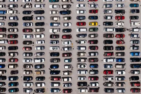 Wiele samochodów różnych marek na parkingu.