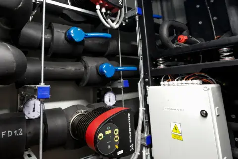 Instalacja grzewcza z pompą Grundfos. Widać rury, zawory i manometry, kluczowe dla efektywności pompy ciepła.