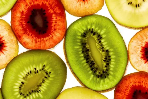 Skivor av kiwi, både gröna och rödaktiga, lyser upp. En påminnelse om att kiwi nyttigt och gott!