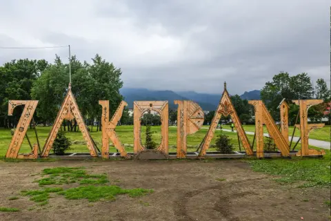 Drewniany napis "ZAKOPANE" na tle gór. Idealne miejsce na rozpoczęcie poszukiwań zakopane atrakcje dla dorosłych.
