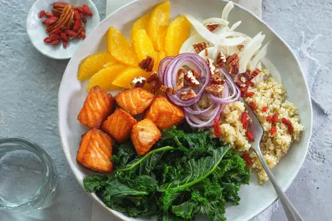 Gesunde Bowl-Rezepte: Lachs, Grünkohl, Quinoa, Orange, Fenchel, rote Zwiebeln, Pekannüsse und Goji-Beeren.