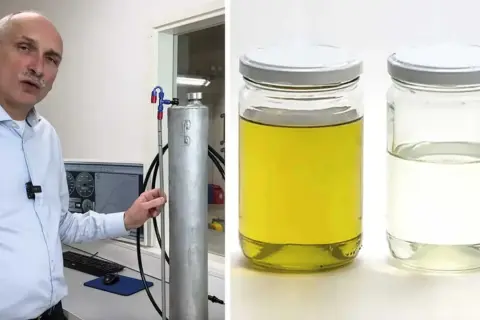 Man visar upp en tank för blankdiesel i personbil. Bredvid står två burkar med vätska, en gul och en klar.