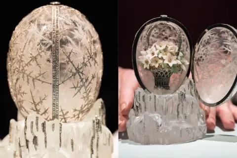 Otwarty jajko Faberge z bukietem kwiatów w koszyku, ozdobione kryształami i diamentami, na lodowym postumencie.