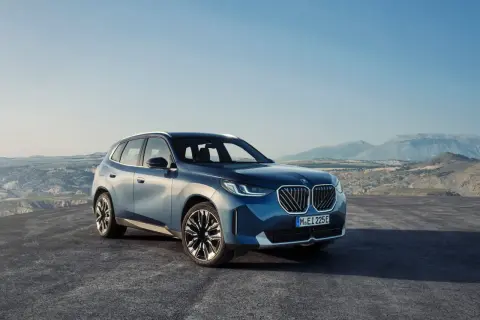 Nowy, błękitny BMW X3 2024 na tle górskiego krajobrazu.