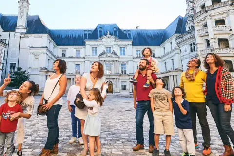 Famille émerveillée devant l'architecture du château de Blois, un lieu chargé d'histoire.