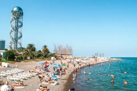 Tłum ludzi na plaży w Batumi, Gruzja. W tle charakterystyczna wieża. Odpowiedź na pytanie: czy w Gruzji jest bezpiecznie? Tak, plaże są pełne turystów.