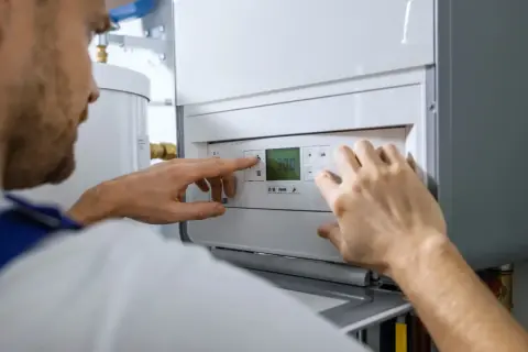 Técnico ajustando la temperatura en una caldera de gas nueva.