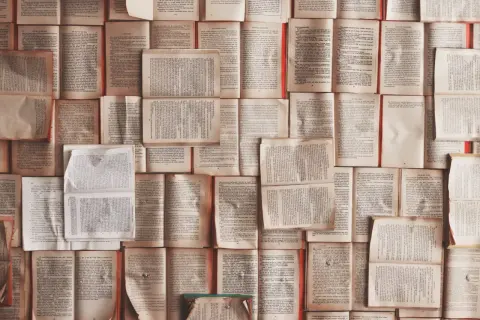 Stos otwartych książek, tworzący tło. Każda strona to nowy precedens, historia czekająca na odkrycie.