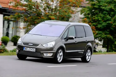 Brązowy Ford Galaxy MK2 w ruchu, z widocznymi felgami i tablicą rejestracyjną WE 2543U.