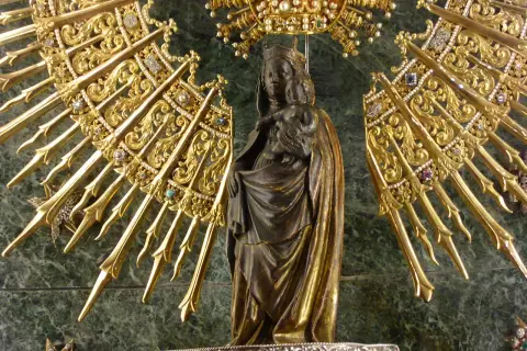 Virgen con Niño, rodeada de un resplandor dorado y joyas, evocando la solemnidad de cuando es la Pilarica.