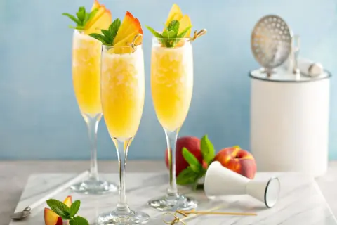 Orzeźwiający mimoza drink z brzoskwinią i miętą, idealny na letnie popołudnie.