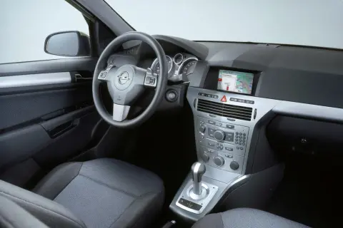 Wnętrze Opla Astry H hatchback: kierownica, deska rozdzielcza z nawigacją, dźwignia zmiany biegów i siedzenie.