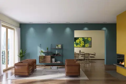 Modernes Wohnzimmer mit zwei Ledersofas, einem Regal und einem Essbereich. Die Wände sind in Petrol und Gelb gestrichen, was zeigt, was ist dispersionsfarbe.