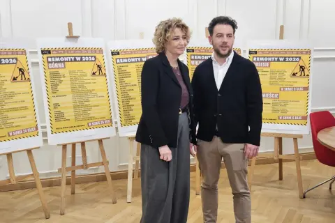 Dwie osoby stoją przed plakatami z listami ulic w Łodzi, na których planowane są remonty w 2026 roku.