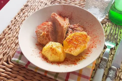 Un plato de carne o caldeiro con patatas, espolvoreado con pimentón.
