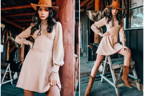 Kobieta w kapeluszu kowbojskim i beżowej sukience prezentuje ubrania w stylu country. Długie rękawy i kozaki dopełniają stylizację.