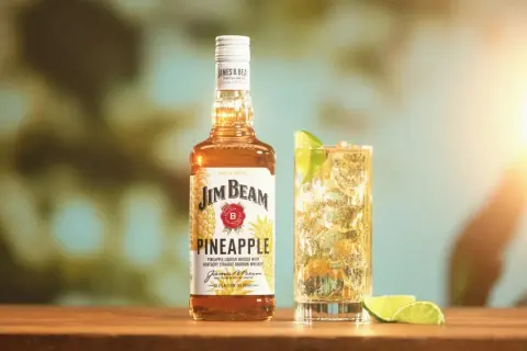 Butelka Jim Beam Pineapple i drink z limonką. Sprawdź, ile procent ma ten słodki, tropikalny likier.