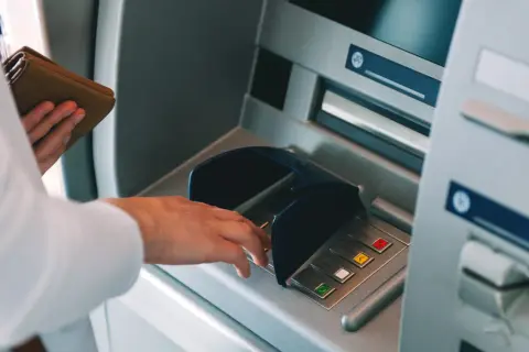 Zestawienie portfela z bankomatem. Niestety, bankomat nie wypłacił pieniędzy, a pobrał z konta.